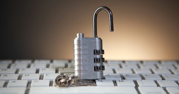 Open padlock with combination lock on keyboard, illustrating blockchain technology in prisons