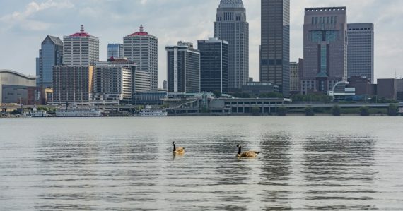 The louisville skyline is seen over the river, illustrating a man facing 600 charges for jail calls