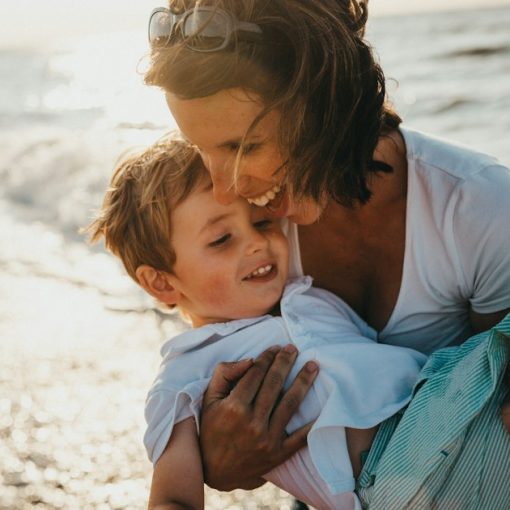 Photo of mother and child beside body of water, illustrating an inmate in trouble for calling family