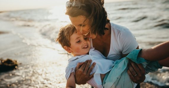 Photo of mother and child beside body of water, illustrating an inmate in trouble for calling family