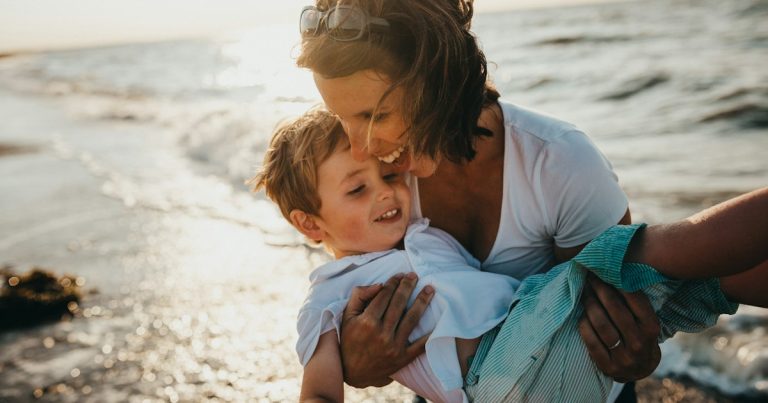 Photo of mother and child beside body of water, illustrating an inmate in trouble for calling family