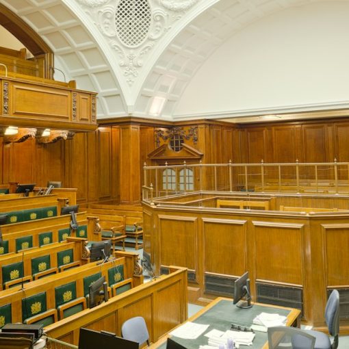 Empty ornate courtroom with wooden paneling and green seats, illustrating whether a phone is dangerous contraband
