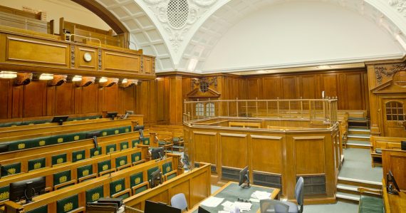 Empty ornate courtroom with wooden paneling and green seats, illustrating whether a phone is dangerous contraband