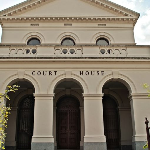 A large white building with a gate in front of it, illustrating the risk of leaving prison phones legal