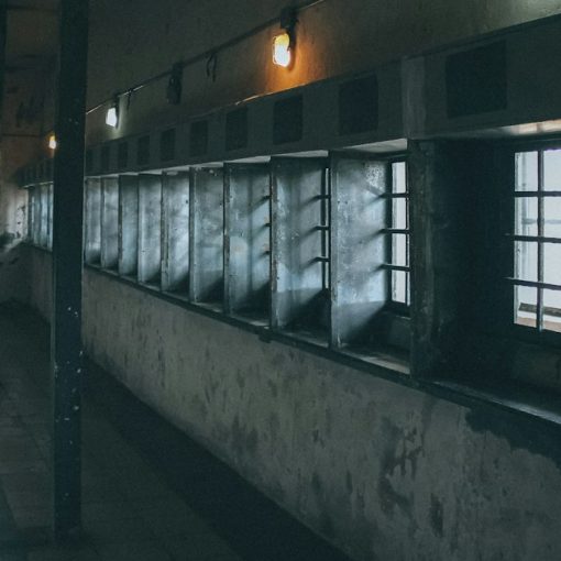 A dimly lit hallway with windows and bars, illustrating staff resisting phone searches