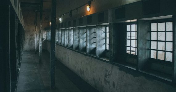 A dimly lit hallway with windows and bars, illustrating staff resisting phone searches