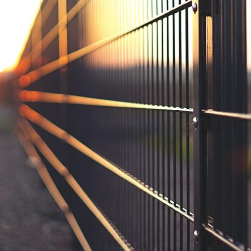 Black metal fence during sunset, illustrating contraband thrown over prison fences
