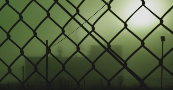 Black metal fence with chain link fence, illustrating supply and demand for contraband phones