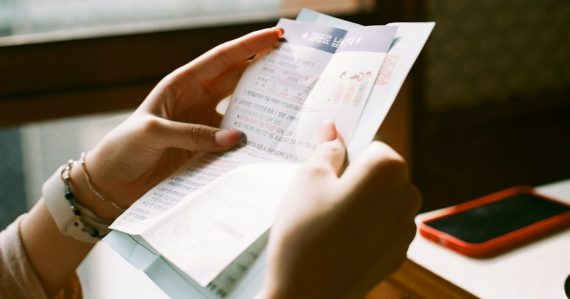 Person holding white printer paper, illustrating California's contraband phone bill advancing