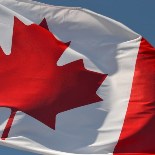 Red and white flag under blue sky during daytime, illustrating contraband phones in Canadian prisons