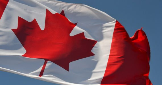 Red and white flag under blue sky during daytime, illustrating contraband phones in Canadian prisons