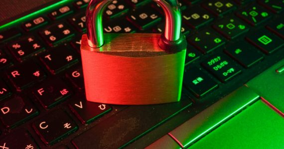 Red padlock on black computer keyboard, illustrating encrypted VoIP on contraband phones