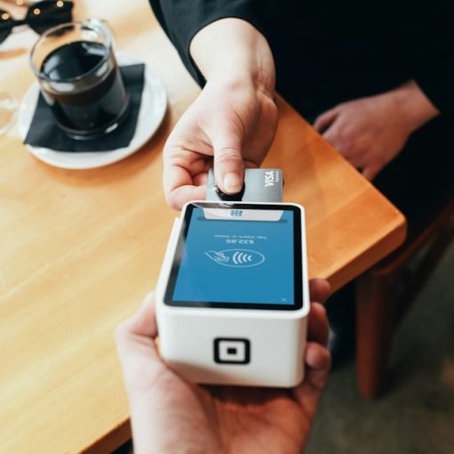 Person holding credit card swipe machine, illustrating an inmate running a credit card scam