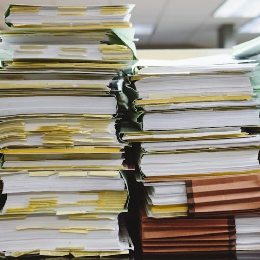 Stacks of paper documents and file folders, illustrating the FCC order on prison payphone rates