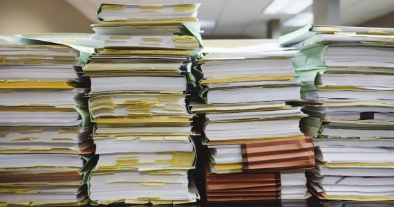 Stacks of paper documents and file folders, illustrating the FCC order on prison payphone rates