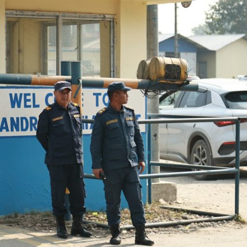 Two police officers and a soldier stand guard at an entrance, illustrating guards keeping contraband out