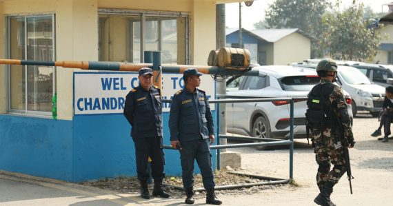 Two police officers and a soldier stand guard at an entrance, illustrating guards keeping contraband out