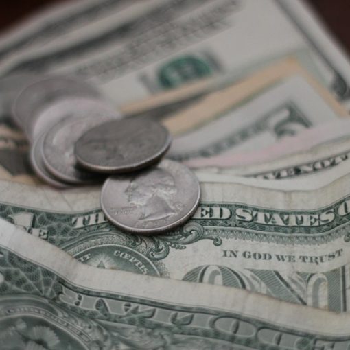 Photo of dollar coins and banknotes, illustrating the high cost of prison phone calls