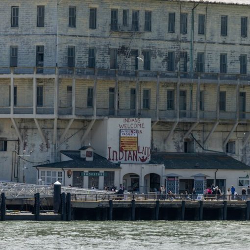 Alcatraz prison building by the water with a dock, illustrating phones as the hottest contraband