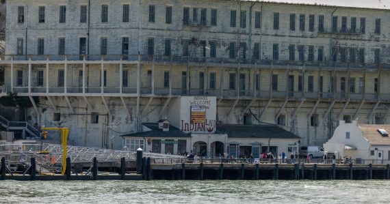 Alcatraz prison building by the water with a dock, illustrating phones as the hottest contraband
