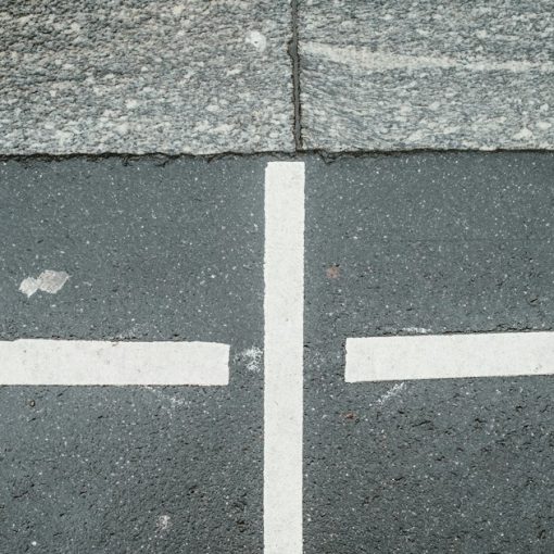 Two white arrows pointing in opposite directions on asphalt, illustrating competition in the prison payphone industry