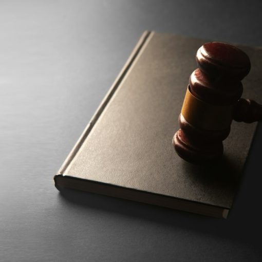 A wooden gavel rests on a closed book, illustrating an inmate pleading guilty to smuggling