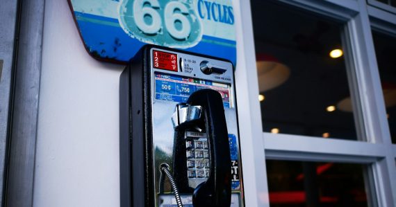 Classic payphone attached to a building wall, illustrating jail phone revenue for counties