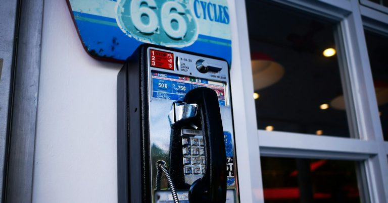 Classic payphone attached to a building wall, illustrating jail phone revenue for counties