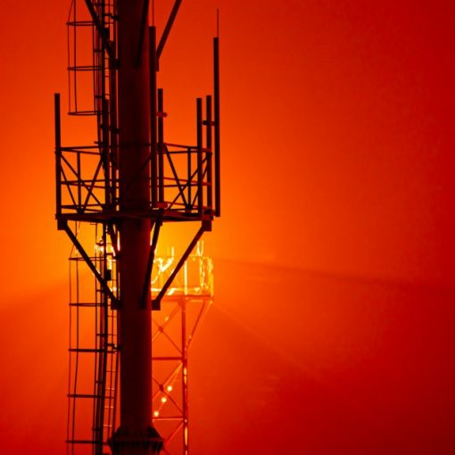 A tall tower sitting next to a red sky, illustrating Texas hoping jammers find phones