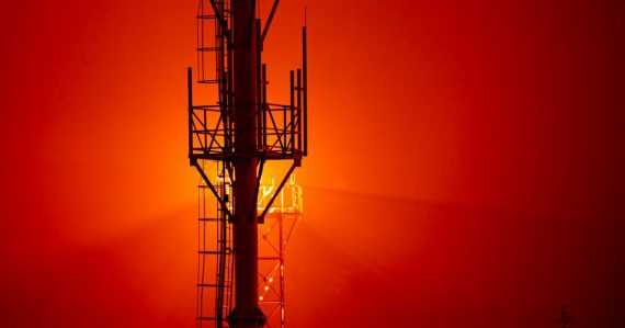 A tall tower sitting next to a red sky, illustrating Texas hoping jammers find phones