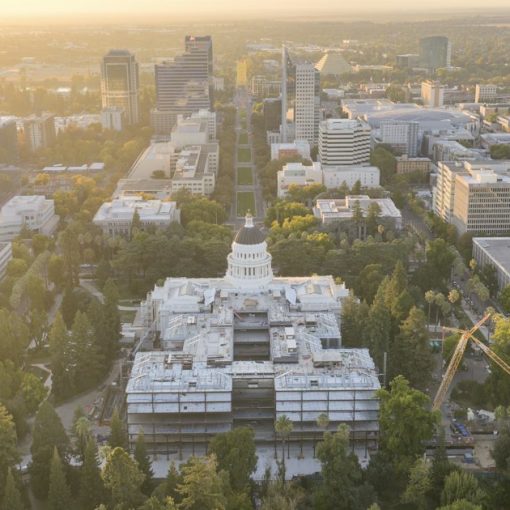 Aerial view of a city capitol building at sunrise, illustrating California's phone ban clearing committee