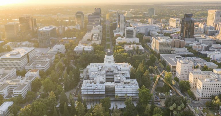 Aerial view of a city capitol building at sunrise, illustrating California's phone ban clearing committee