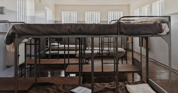 A bunk bed in a room with a lot of windows, illustrating amenities in a women's prison