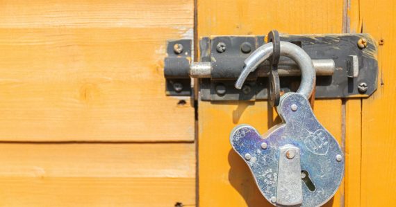 Brown wooden door with padlock, illustrating Mississippi's penalties for phone possession