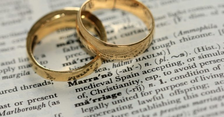 Two gold-colored rings on paper, illustrating a prisoner's phone and his marriage