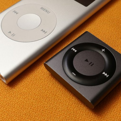 An iPod sitting next to an mp3 player on a bed, illustrating MP3 players in federal prisons