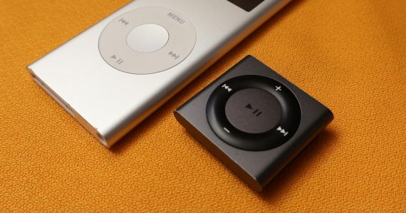 An iPod sitting next to an mp3 player on a bed, illustrating MP3 players in federal prisons