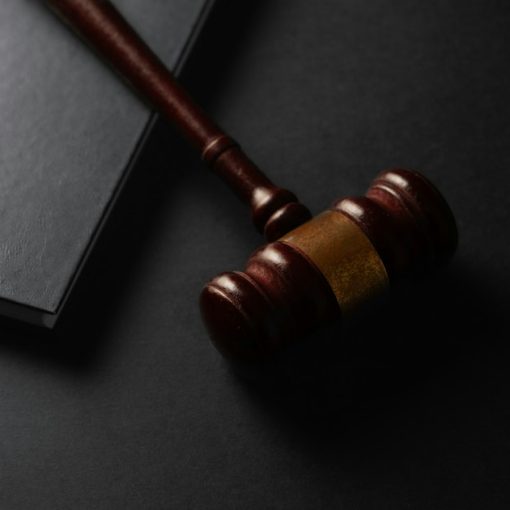 Wooden gavel resting on a dark surface next to book, illustrating a NJ officer convicted of smuggling