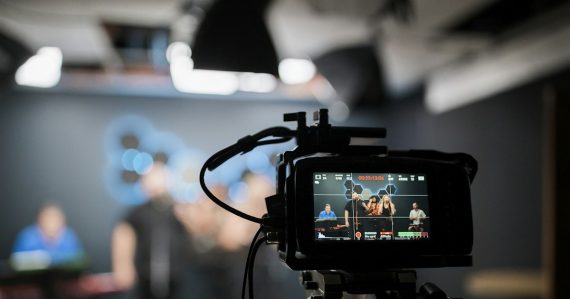 A professional video camera recording a group in a studio, illustrating a New Jersey phone investigation video