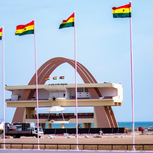 Ghana's independence square with flags and a clear sky, illustrating officers smuggling phones in Ghana