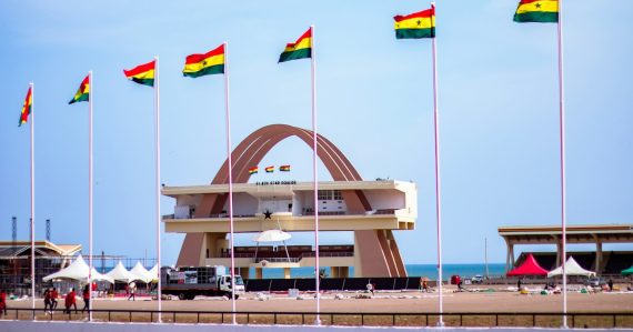 Ghana's independence square with flags and a clear sky, illustrating officers smuggling phones in Ghana