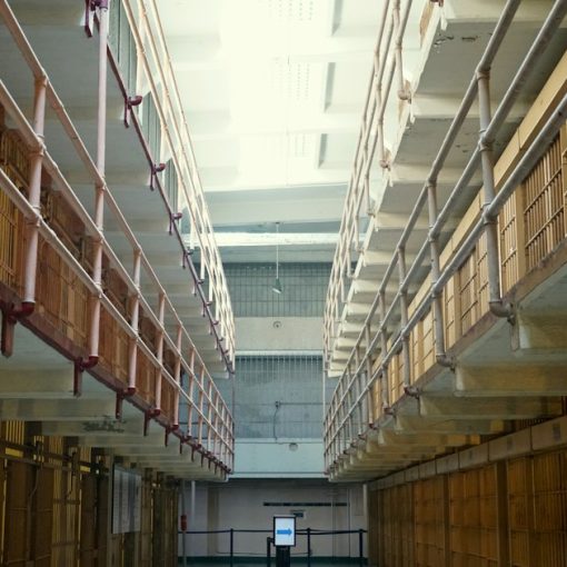 Man in black jacket walking on hallway, illustrating a guard pleading guilty to smuggling