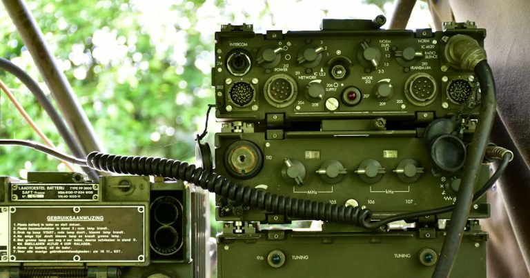 Military radio equipment on a wooden table, illustrating problems with prison cell phone jammers