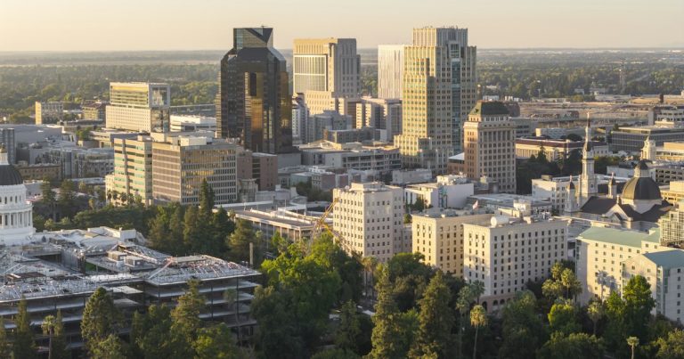 City skyline with modern buildings at sunset, illustrating California's new push against prison phones