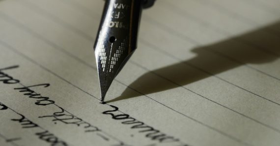 Fountain pen on black lined paper, illustrating California's prison cellphone bill