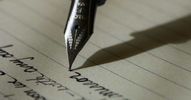 Fountain pen on black lined paper, illustrating California's prison cellphone bill