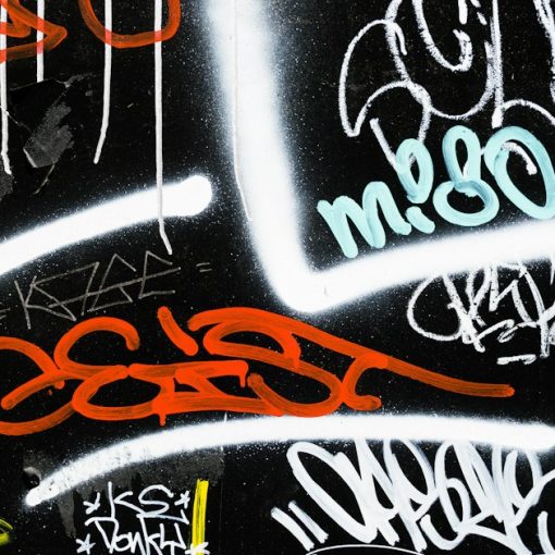 Black and multicolored graffiti art, illustrating gangs using phones behind bars