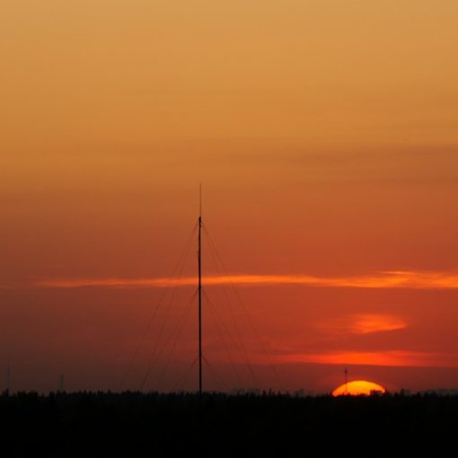 Sunset over the horizon with radio towers, illustrating risks of prison micro-jamming