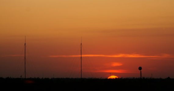 Sunset over the horizon with radio towers, illustrating risks of prison micro-jamming