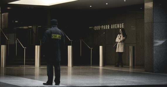 Security guard standing on the gray floor, illustrating a prison shakedown finding phones